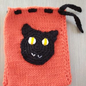 pochette à bonbons tricotée avec motif thématique au crochet cousu dessus
