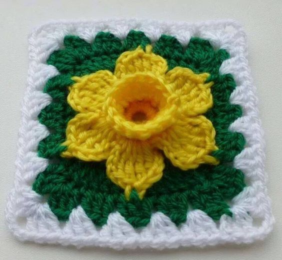 Carré au crochet avec une jonquille au crochet incrustée au centre de celui-ci en relief
